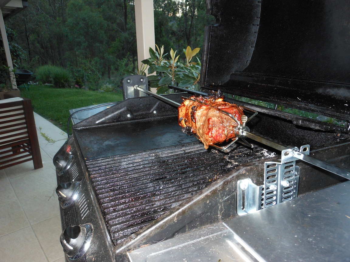Another picture of beef being cooked in a gas BBQ on a Rotisserie